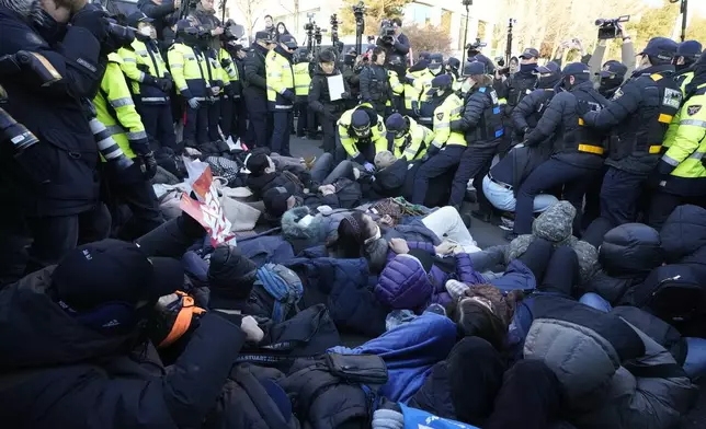 Police officers drag away supporters of impeached South Korean President Yoon Suk Yeol as Yoon faces potential arrest after a court on Tuesday approved a warrant for his arrest, near the presidential residence in Seoul, South Korea, Thursday, Jan. 2, 2025. (AP Photo/Ahn Young-joon)