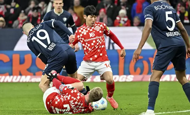 Mainz's Hyun-seok Hong, center vies for the ball with Bochum's Matus Bero, during the German Bundesliga soccer match between FSV Mainz 05 and VfL Bochum 1848, in Mainz, Germany, Saturday, Jan 11, 2025. (Torsten Silz/dpa via AP)