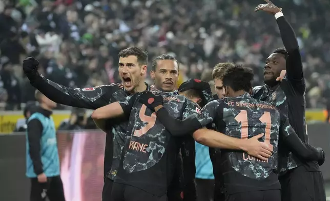 Bayern's Harry Kane celebrates with teammates after scoring the opening goal during the German Bundesliga soccer match between Borussia Moenchengladbach and Bayern Munich in Moenchengladbach, Germany, Saturday, Jan. 11, 2025. (AP Photo/Martin Meissner)