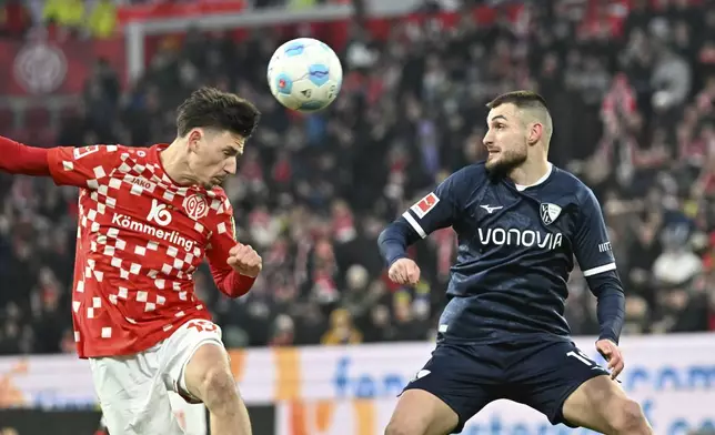 Mainz's Anthony Caci, left, vies for the ball with Bochum's Matus Bero, during the German Bundesliga soccer match between FSV Mainz 05 and VfL Bochum 1848, in Mainz, Germany, Saturday, Jan 11, 2025. (Torsten Silz/dpa via AP)