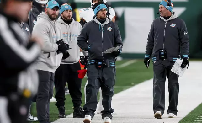 Miami Dolphins head coach Mike McDaniels, center, walks on the sideline during the second half of an NFL football game against the New York Jets, Sunday, Jan. 5, 2025, in East Rutherford, N.J. (AP Photo/Noah K. Murray)