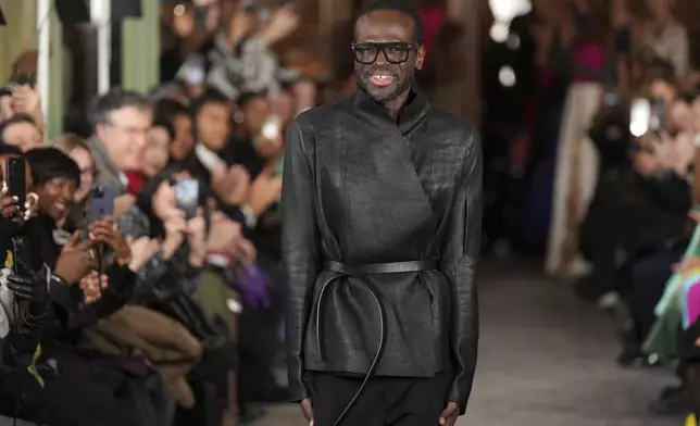Fashion designer Imane Ayissi accepts applauses after his Haute Couture Spring Summer 2025 collection, that was presented in Paris, Monday, Jan. 27, 2025. (AP Photo/Lewis Joly)