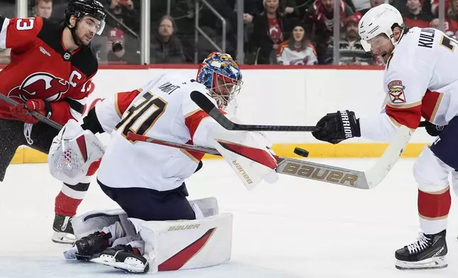 Florida Panthers goaltender Spencer Knight (30) makes a save during the second period of an NHL hockey game against the New Jersey Devils, Tuesday, Jan. 14, 2025, in Newark, N.J. (AP Photo/Julia Demaree Nikhinson)