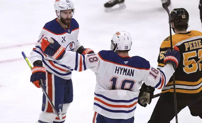 Edmonton Oilers center Adam Henrique, left, is congratulated by Zach Hyman (18) after his goal agains the Boston Bruins during the second period of an NHL hockey game, Tuesday, Jan. 7, 2025, in Boston. (AP Photo/Charles Krupa)