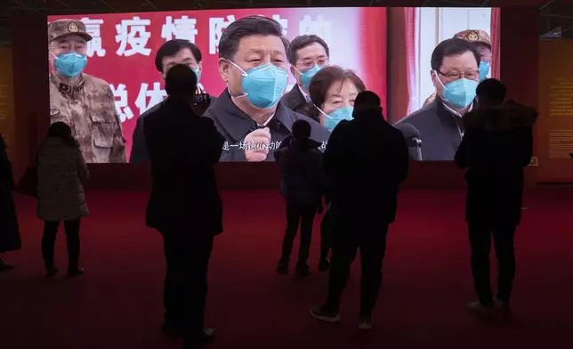 FILE - People attend an exhibition on the city's fight against the coronavirus in Wuhan in central China's Hubei province, Jan. 23, 2021. (AP Photo/Ng Han Guan, File)