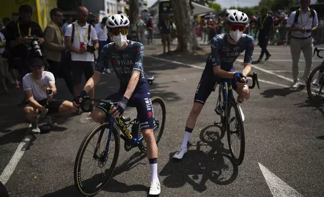 FILE - Denmark's Jonas Vingegaard, left, and teammate Matteo Jorgenson, of the U.S., wear face masks to protect themselves from the Corona virus prior to the start of the fourteenth stage of the Tour de France cycling race over 151.9 kilometers (94.4 miles) with start in Pau and finish in Saint-Lary-Soulan Pla d'Adet, France, July 13, 2024. Several riders had to abandon the race after contracting COVID-19. (AP Photo/Daniel Cole, File)