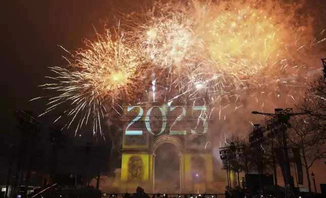 A light show is projected on the Arc de Triomphe as fireworks explode during New Year's celebrations on the Champs Elysees in Paris, France, Wednesday, Jan. 1, 2025. (AP Photo/Thibault Camus)