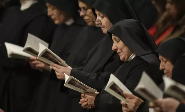 Nuns read prayer books as they attend New Year's Eve Vespers and Te Deum celebrations with Pope Francis in St. Peter's Basilica at the Vatican, Tuesday, Dec. 31, 2024. (AP Photo/Andrew Medichini)