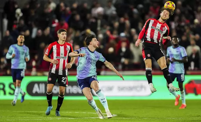 Brentford's Mathias Jensen heads the ball next to Arsenal's Declan Rice, center, during the English Premier League soccer match between Brentford and Arsenal at the Gtech Community stadium in London, Wednesday, Jan. 1, 2025. (AP Photo/Kirsty Wigglesworth)