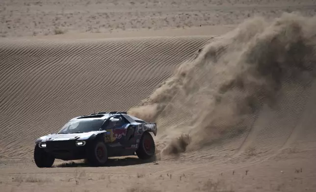 Driver Carlos Sainz and co-driver Lucas Cruz compete during the stage two, day One, of the Dakar Rally with start in Bisha and finish in Bisha, Saudi Arabia, Sunday, Jan. 5, 2025. (AP Photo/Christophe Ena)