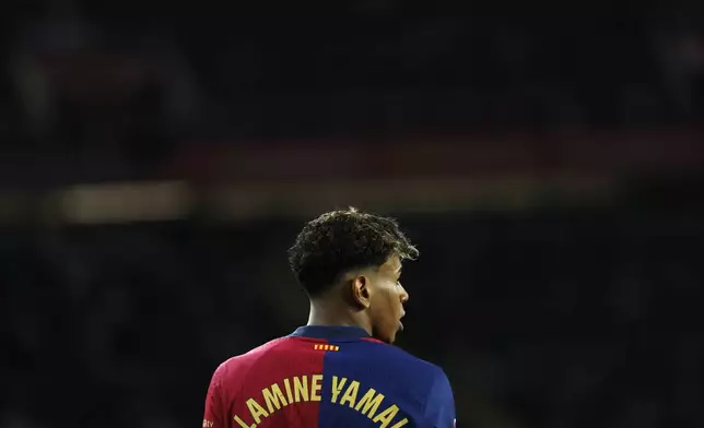 Barcelona's Lamine Yamal walks during the Spanish La Liga soccer match between Barcelona and Valencia at the Lluis Companys Olympic Stadium in Barcelona, Spain, Sunday, Jan. 26, 2025. (AP Photo/Joan Monfort)