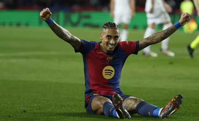 Barcelona's Raphinha celebrates after Fermin Lopez, not in the picture, scored his side's fifth goal during the Spanish La Liga soccer match between Barcelona and Valencia at the Lluis Companys Olympic Stadium in Barcelona, Spain, Sunday, Jan. 26, 2025. (AP Photo/Joan Monfort)