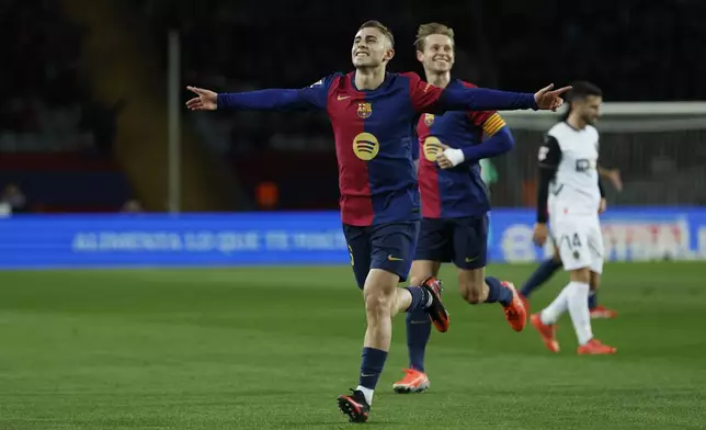 Barcelona's Fermin Lopez, left, celebrates with Frenkie de Jong after scoring his side's fourth goal during the Spanish La Liga soccer match between Barcelona and Valencia at the Lluis Companys Olympic Stadium in Barcelona, Spain, Sunday, Jan. 26, 2025. (AP Photo/Joan Monfort)