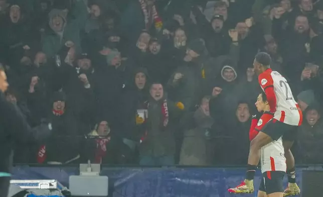 Feyenoord's Ayase Ueda celebrates with Feyenoord's Jeyland Mitchell after scoring his side's third goal during the Champions League opening phase soccer match between Feyenoord and Bayern Munich, at De Kuip Stadium, in Rotterdam, Netherlands, Wednesday, Jan. 22, 2025. (AP Photo/Peter Dejong)