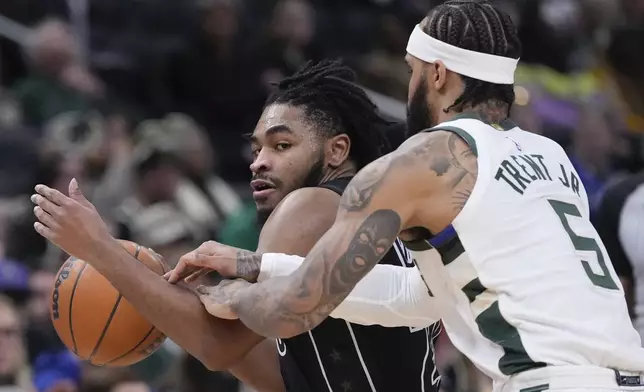 Brooklyn Nets' Cam Thomas tries to get past Milwaukee Bucks' Gary Trent Jr. during the first half of an NBA basketball game Thursday, Jan. 2, 2025, in Milwaukee. (AP Photo/Morry Gash)