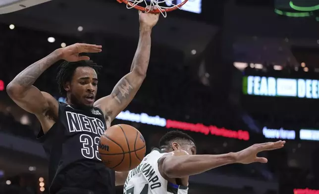 Brooklyn Nets' Nic Claxton dunks past Milwaukee Bucks' Giannis Antetokounmpo during the first half of an NBA basketball game Thursday, Jan. 2, 2025, in Milwaukee. (AP Photo/Morry Gash)