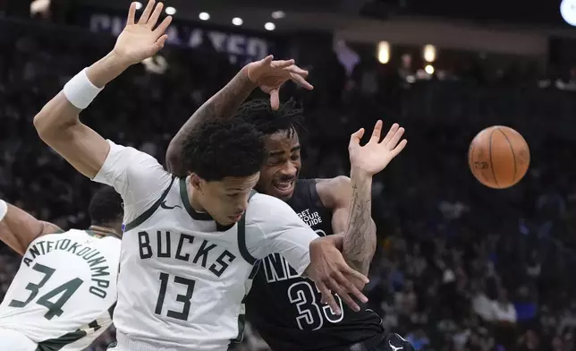 Milwaukee Bucks' Ryan Rollins and Brooklyn Nets' Nic Claxton go after a loose ball during the first half of an NBA basketball game Thursday, Jan. 2, 2025, in Milwaukee. (AP Photo/Morry Gash)