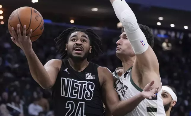 Brooklyn Nets' Cam Thomas shoots past Milwaukee Bucks' Brook Lopez during the first half of an NBA basketball game Thursday, Jan. 2, 2025, in Milwaukee. (AP Photo/Morry Gash)