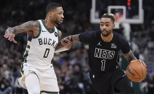 Brooklyn Nets' D'Angelo Russell tries to get past Milwaukee Bucks' Damian Lillard during the first half of an NBA basketball game Thursday, Jan. 2, 2025, in Milwaukee. (AP Photo/Morry Gash)