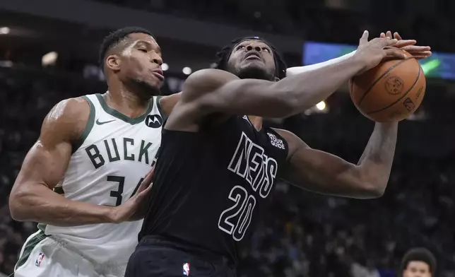 Milwaukee Bucks' Giannis Antetokounmpo fouls Brooklyn Nets' Maxwell Lewis during the first half of an NBA basketball game Thursday, Jan. 2, 2025, in Milwaukee. (AP Photo/Morry Gash)