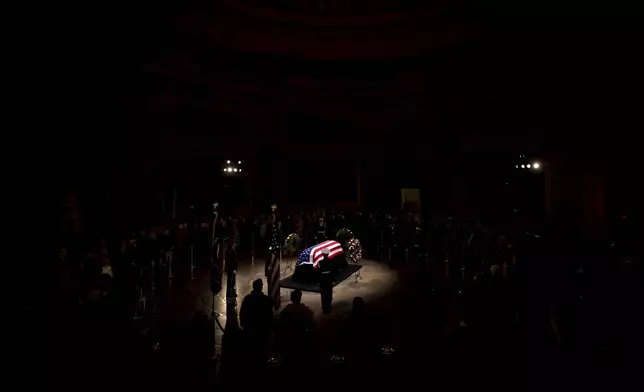 Members of the public view the flag-draped casket of former President Jimmy Carter as it lies in state in the Rotunda, at the Capitol in Washington, Tuesday, Jan. 7, 2025. (AP Photo/Ben Curtis)