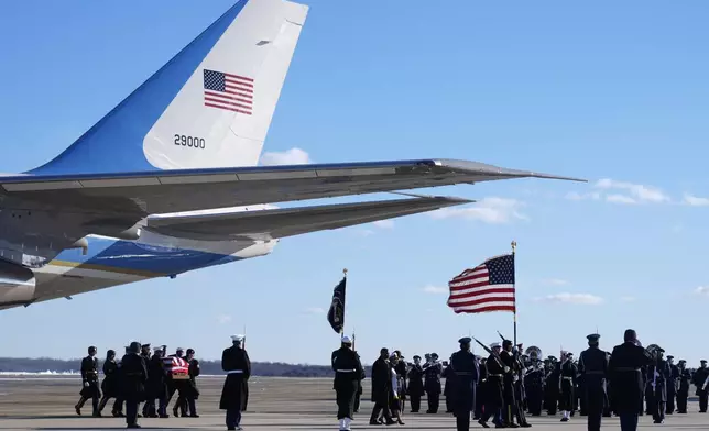 A joint forces body bearer team moves the flag-draped casket of former President Jimmy Carter upon arrival at Joint Base Andrews, Md., Tuesday, Jan. 7, 2025. Carter died Dec. 29, at the age of 100. (AP Photo/Susan Walsh, Pool)