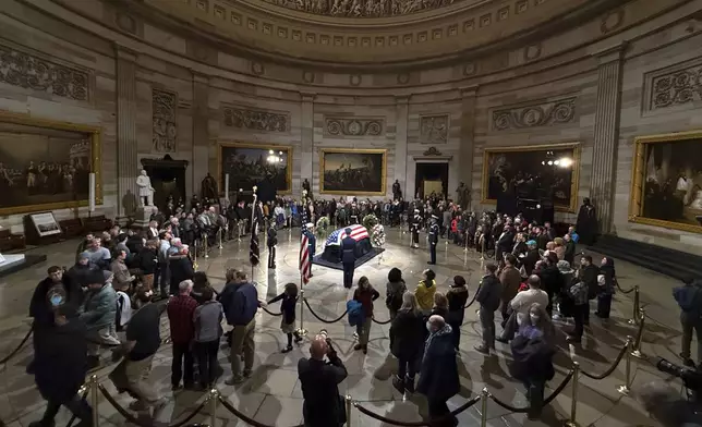 Mourners look at the flag-draped casket of former President Jimmy Carter as he lies in state in the Capitol, Tuesday, Jan. 7, 2025, in Washington. Carter died Dec. 29 at the age of 100. (AP Photo/Jose Luis Magana)