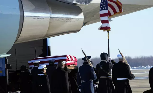 A joint forces body bearer team moves the flag-draped casket of former President Jimmy Carter upon arrival at Joint Base Andrews, Md., Tuesday, Jan. 7, 2025. Carter died Dec. 29, at the age of 100. (AP Photo/Susan Walsh, Pool)