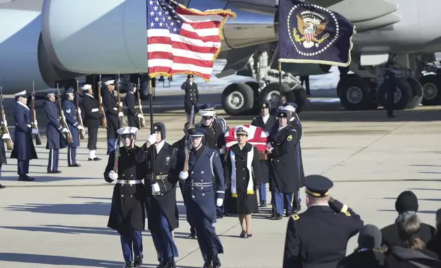 A joint services military body bearer team carries the flag-draped casket of former President Jimmy Carter on arrival at Joint Base Andrews, Md., Tuesday, Jan. 7, 2025, and will travel on to the Capitol where he will lie in State. Carter died Dec. 29 at the age of 100. (AP Photo/Steve Helber)