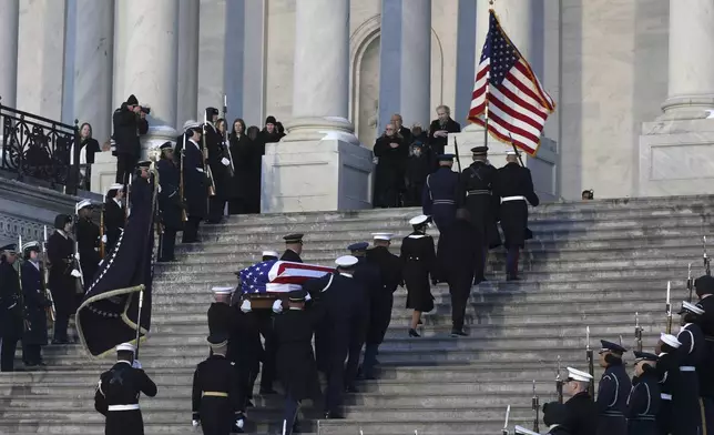 A joint services military body bearer team carries the flag-draped casket of former President Jimmy Carter up the steps into the U.S Capitol, Tuesday, Jan. 7, 2025, in Washington. Carter died Dec. 29 at the age of 100. (Evelyn Hockstein/Pool via AP)