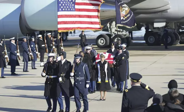 A joint services military body bearer team carries the flag-draped casket of former President Jimmy Carter on arrival at Joint Base Andrews, Md., Tuesday, Jan. 7, 2025, and will travel on to the Capitol where he will lie in State. Carter died Dec. 29 at the age of 100. (AP Photo/Steve Helber)