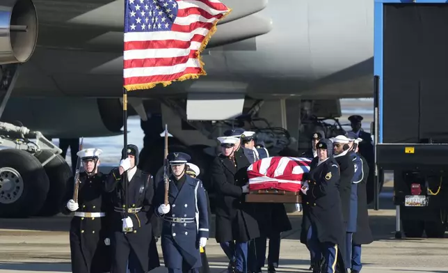 A joint services military body bearer team carries the flag-draped casket of former President Jimmy Carter on arrival at Joint Base Andrews, Md., Tuesday, Jan. 7, 2025, and will travel on to the Capitol where he will lie in State. Carter died Dec. 29 at the age of 100. (AP Photo/Steve Helber)