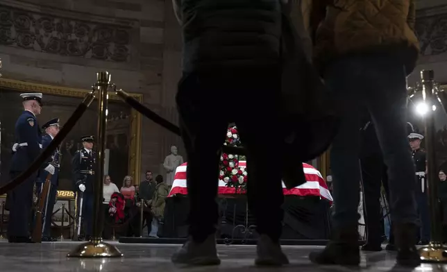 Mourners look at the flag-draped casket of former President Jimmy Carter as he lies in state in the Capitol, Tuesday, Jan. 7, 2025, in Washington. Carter died Dec. 29 at the age of 100. (AP Photo/Jose Luis Magana)