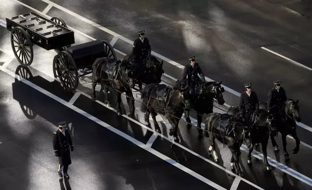 A horse-drawn caisson awaits the arrival of former President Jimmy Carter's casket at the U.S. Navy Memorial before traveling on to the Capitol in Washington to lie in state, Tuesday, Jan. 7, 2025. Carter died Dec. 29 at the age of 100. (AP Photo/Mark Schiefelbein, Pool)