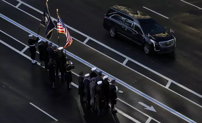 A hearse carrying the flag-draped casket of former President Jimmy Carter arrives to be transferred to a horse-drawn caisson at the U.S. Navy Memorial before traveling on to the Capitol in Washington, Tuesday, Jan. 7, 2025, where Carter will lie in state. Carter died Dec. 29 at the age of 100. (AP Photo/Mark Schiefelbein, Pool)