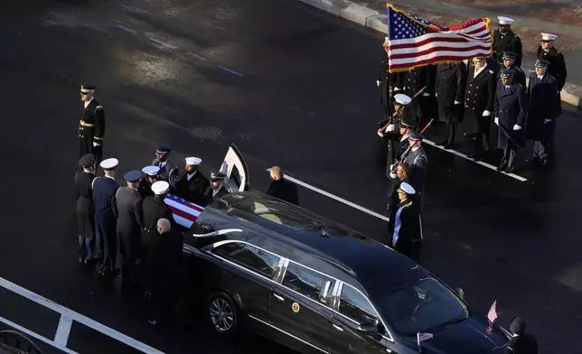 The flag-draped casket of former President Jimmy Carter is transferred from a hearse to a horse-drawn caisson at the U.S. Navy Memorial before traveling on to the Capitol in Washington, Tuesday, Jan. 7, 2025, where Carter will lie in state. Carter died Dec. 29 at the age of 100. (AP Photo/Mark Schiefelbein, Pool)