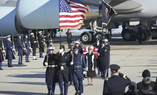 A joint services military body bearer team carries the flag-draped casket of former President Jimmy Carter on arrival at Joint Base Andrews, Md., Tuesday, Jan. 7, 2025, and will travel on to the Capitol where he will lie in State. Carter died Dec. 29 at the age of 100. (AP Photo/Steve Helber)