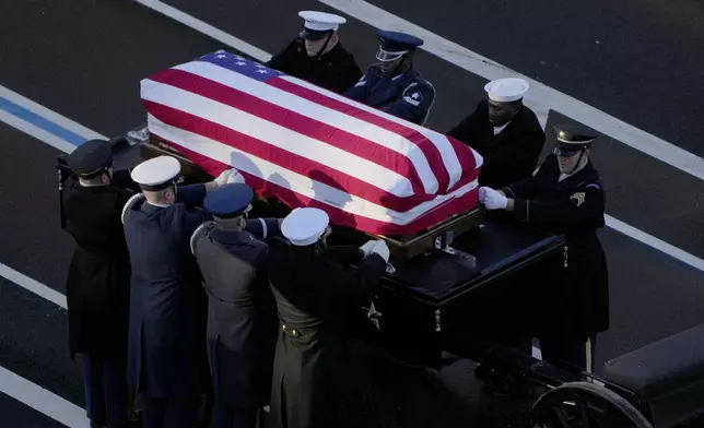 The flag-draped casket of former President Jimmy Carter is transferred to a horse-drawn caisson at the U.S. Navy Memorial before traveling on to the Capitol in Washington, Tuesday, Jan. 7, 2025, where Carter will lie in state. Carter died Dec. 29 at the age of 100. (AP Photo/Mark Schiefelbein, Pool)