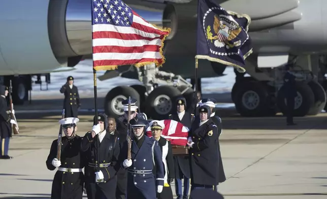 A joint services military body bearer team carries the flag-draped casket of former President Jimmy Carter on arrival at Joint Base Andrews, Md., Tuesday, Jan. 7, 2025, and will travel on to the Capitol where he will lie in State. Carter died Dec. 29 at the age of 100. (AP Photo/Steve Helber)