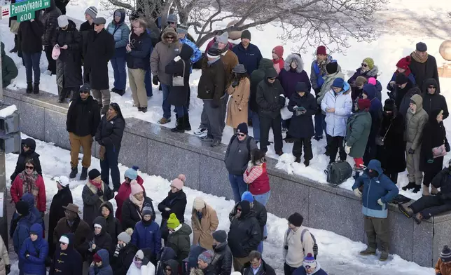 Spectators wait for the casket of former President Jimmy Carter to arrive at the U.S. Navy Memorial before traveling on to the Capitol in Washington, Tuesday, Jan. 7, 2025, where Carter will lie in state. Carter died Dec. 29 at the age of 100. (AP Photo/Mark Schiefelbein, Pool)