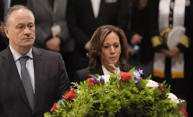 Second gentleman Doug Emhoff, left, and Vice President Kamala Harris place a wreath at the flag-draped casket of former President Jimmy Carter during a ceremony where Carter lies in state at the Capitol in Washington, Tuesday, Jan. 7, 2025. Carter died Dec. 29 at the age of 100. (AP Photo/J. Scott Applewhite, Pool)