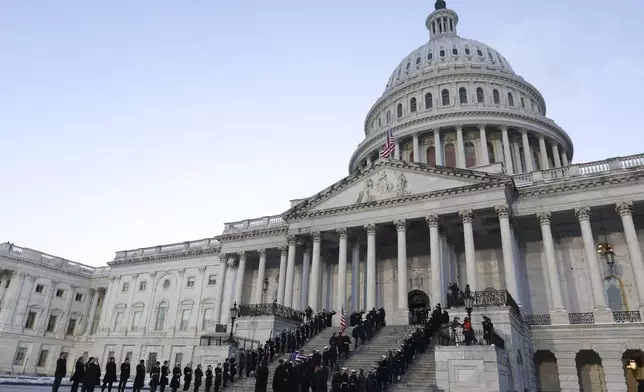 A joint services military body bearer team carries the flag-draped casket of former President Jimmy Carter up the steps into the U.S Capitol, Tuesday, Jan. 7, 2025, in Washington. Carter died Dec. 29 at the age of 100. (Evelyn Hockstein/Pool via AP)