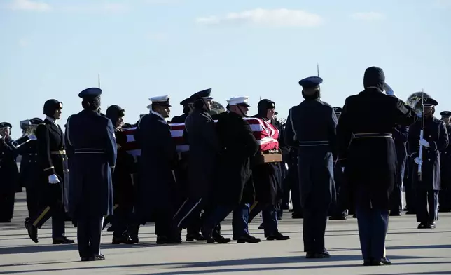 A joint forces body bearer team moves the flag-draped casket of former President Jimmy Carter upon arrival at Joint Base Andrews, Md., Tuesday, Jan. 7, 2025. Carter died Dec. 29, at the age of 100. (AP Photo/Susan Walsh, Pool)