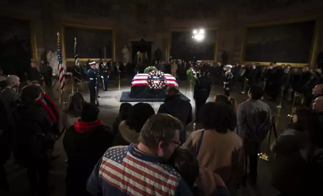 Mourners look at the flag-draped casket of former President Jimmy Carter as he lies in state in the Capitol, Tuesday, Jan. 7, 2025, in Washington. Carter died Dec. 29 at the age of 100. (AP Photo/Ben Curtis)