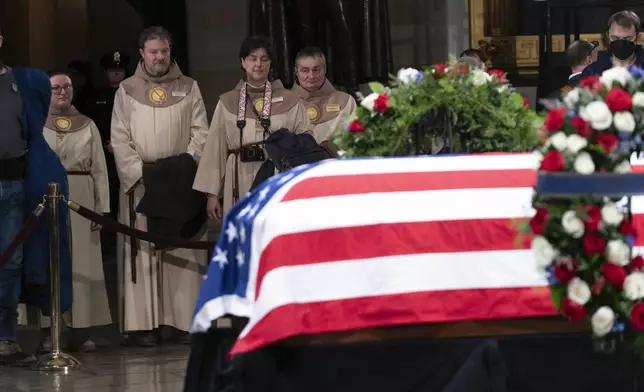 Mourners look at the flag-draped casket of former President Jimmy Carter as he lies in state in the Capitol, Tuesday, Jan. 7, 2025, in Washington. Carter died Dec. 29 at the age of 100. (AP Photo/Jose Luis Magana)