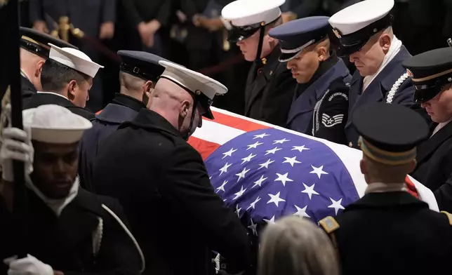 A joint services military body bearer team carries the flag-draped casket of former President Jimmy Carter to lie in state at the U.S. Capitol, Tuesday, Jan. 7, 2025, in Washington. Carter died Dec. 29, at the age of 100. (AP Photo/J. Scott Applewhite, Pool)