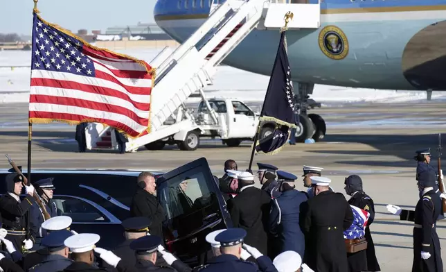 A joint services military body bearer team places the flag-draped casket of former President Jimmy Carter into a hearse on arrival at Joint Base Andrews, Md., Tuesday, Jan. 7, 2025, and will then travel to the Capitol where he will lie in State. Carter died Dec. 29 at the age of 100. (AP Photo/Steve Helber)