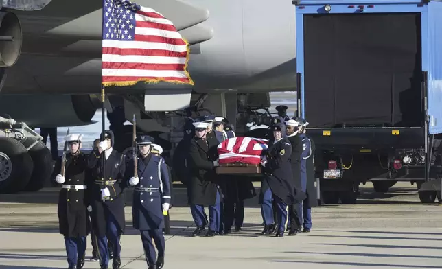 A joint services military body bearer team carries the flag-draped casket of former President Jimmy Carter on arrival at Joint Base Andrews, Md., Tuesday, Jan. 7, 2025, and will travel on to the Capitol where he will lie in State. Carter died Dec. 29 at the age of 100. (AP Photo/Steve Helber)