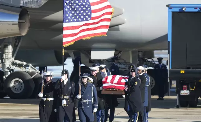 A joint services military body bearer team carries the flag-draped casket of former President Jimmy Carter on arrival at Joint Base Andrews, Md., Tuesday, Jan. 7, 2025, and will travel on to the Capitol where he will lie in State. Carter died Dec. 29 at the age of 100. (AP Photo/Steve Helber)