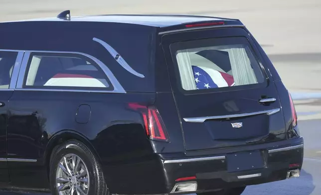 A hearse carrying the flag-draped casket of former President Jimmy Carter departs Joint Base Andrews, Md., following his arrival, Tuesday, Jan. 7, 2025, and will travel to the Capitol where he will lie in State. Carter died Dec. 29 at the age of 100. (AP Photo/Steve Helber)